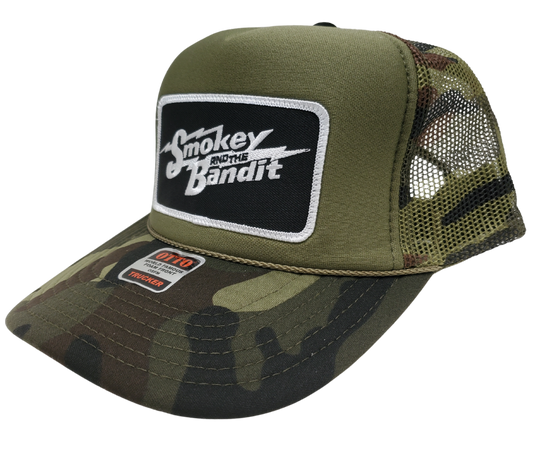 Take risks and show your adventurous spirit with our black and green camo mesh vintage foam trucker Smoky and the Bandit cap! The iconic Bandit logo meets the USA flag in this unique design. Get yours now at our Smyrna, TN store or online for the ultimate challenge and inspiration! Snap back adjustment.