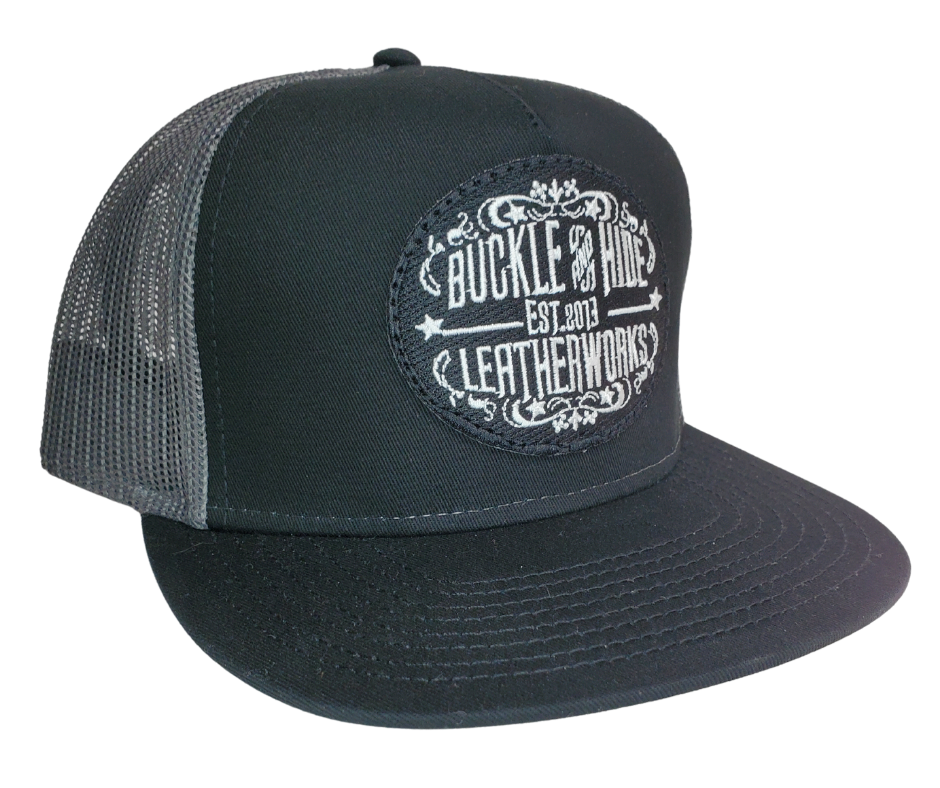 Upgrade your cap game with the Buckle and Hide Classic Flat Bill Trucker Cap, featuring a stylish mesh back, structured top and a snap back. Choose from Black, Grey, Gray/Black or Blk/Gray and proudly wear the Buckle and Hide patch on the front. From your favorite leather shop in Smyrna, TN, just outside of Nashville.