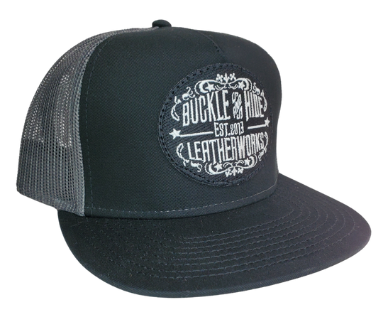 Upgrade your cap game with the Buckle and Hide Classic Flat Bill Trucker Cap, featuring a stylish mesh back, structured top and a snap back. Choose from Black, Grey, Gray/Black or Blk/Gray and proudly wear the Buckle and Hide patch on the front. From your favorite leather shop in Smyrna, TN, just outside of Nashville.