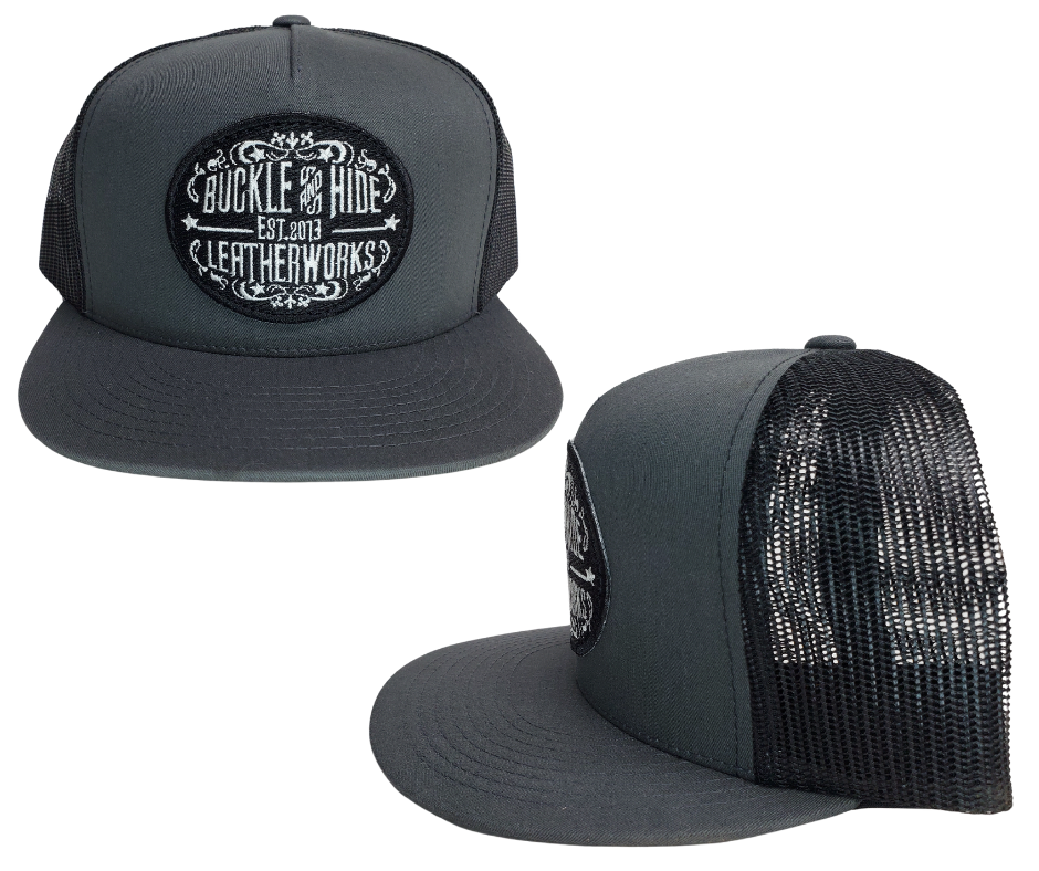 Upgrade your cap game with the Buckle and Hide Classic Flat Bill Trucker Cap, featuring a stylish mesh back, structured top and a snap back. Choose from Black, Grey, Gray/Black or Blk/Gray and proudly wear the Buckle and Hide patch on the front. From your favorite leather shop in Smyrna, TN, just outside of Nashville.