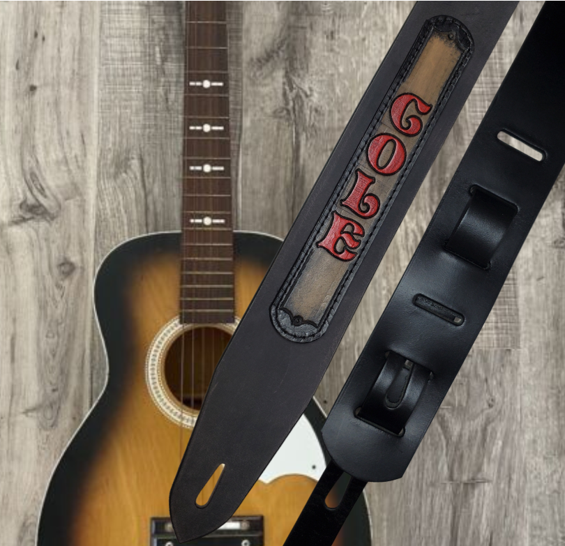 Acoustic Guitars and Great Songs and Lyrics have been staple for years in Country music!  "This 2" or 2 1/2" wide Guitar Strap is a nod to that classic influence. The main Body of the strap is approx. 1/8" thick Black Leather Strap with a CUSTOMIZABLE LEATHER NAME PATCH. The classic adjustment style goes from approx. 42" to 56" at it's longest . Made just outside Nashville in our Smyrna, TN. shop. It will need a bit of time to "break in" but will get a great patina over time.   