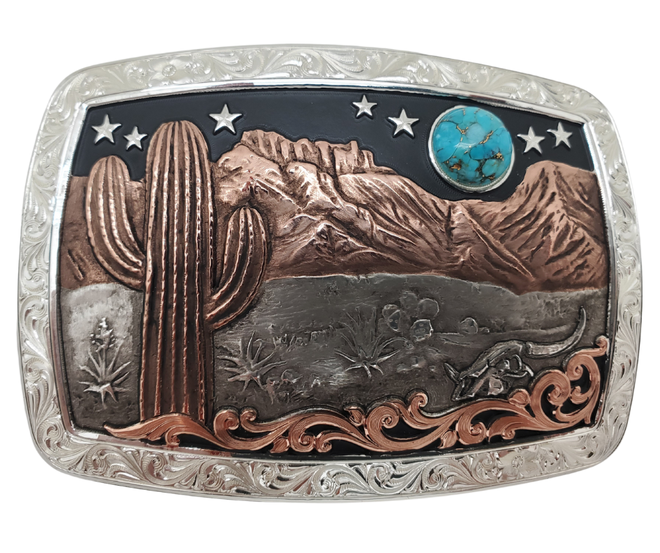 A Southwest buckle that's not so big! This 99% Silver rectangular belt buckle has Scroll work around the outer edge with a 18 karat Rose Gold Cactus, Mountains and a Turquoise Moon over the Desert scene. It's size is approx. 3" across x 2 1/2" tall and fits 3 3/4", fits up to 1 1/2" belts. Available at our Smyrna, TN just a short drive from downtown Nashville. Made by Montana Silversmith.