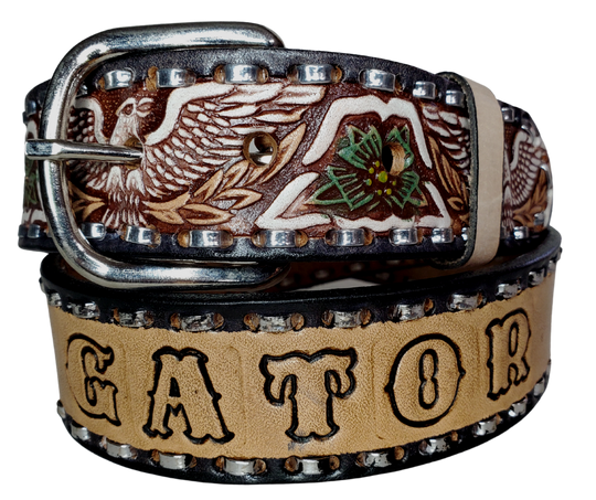 The Dimestore Cowboy leather belt is a classic Vintage Throwback Style Western belt. Complete with silver Buck Stitching and a embossed eagle design in Black/Antique White/Blue coloring. A 1 1/2" width Full grain vegetable tanned cowhide, Width 1 1/2" and includes Nickle plated  buckle Smooth burnished painted edges. Buckle snaps in place for easy changing if desired. In stock at our Smyrna, TN shop. 