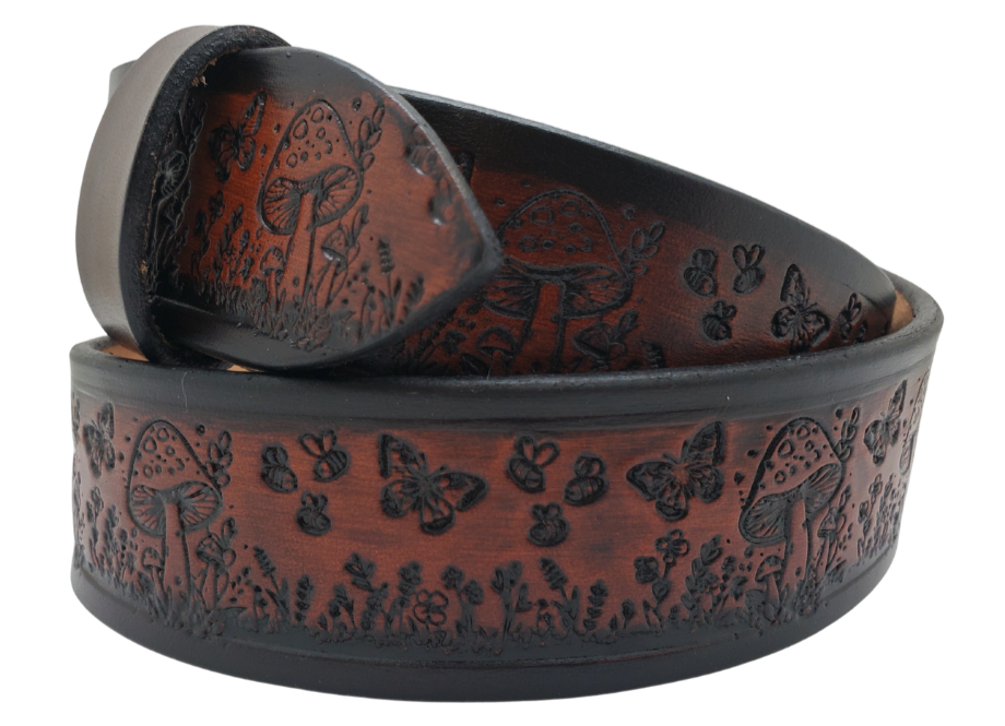 Our 1 1/2" Throwback Groovy Mushroom is a solid strip of USA veg-tan cowhide, embossed with a scene of Mushrooms, Flowers, and Butterflies down length of belt. It is hand finished in&nbsp;3 finishes, with smooth beveled, and painted edges, approx. 1/8" thick. Sizes available are&nbsp;34" to 44" from buckle end to hole most worn.&nbsp; Buckle is an Antique Silver finish brass, held in place with 2 snaps for easy buckle change. Crafted by hand at our Smyrna, Tennessee shop, close to Nashville.