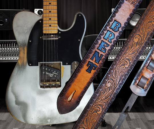 Great Session Musicians, and great songs have been a staple for years in Nashville. This Guitar Strap is a nod to those great Musicians influence! The 2' wide main Body of the strap is approx. 1/8" thick Embossed Veg-Tan Leather Strap with a CUSTOMIZABLE NAME FONT and Strap color. The classic adjustment style goes from approx. 42" to 56" at it's longest . Made just outside Nashville in our Smyrna, TN. shop. It will need a bit of time to "break in" but will get a great patina over time.  