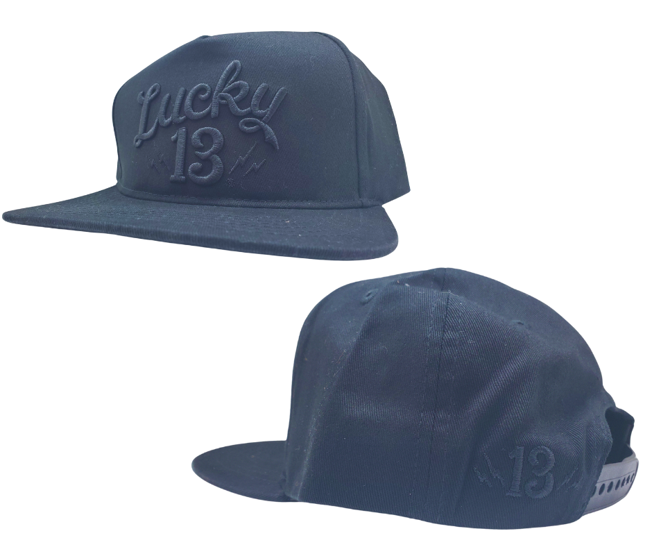 The Lucky 13 Shocker solid twill snapback trucker cap has the vintage-inspired "Lucky 13" graphic on front and a "Lightning Bolt 13" embroidered on the back left side. There is an adjustable snap back to assist in helping this hat fit almost any size head. Come and and get'em at our Smyrna, TN shop a short ride outside Nashville.

COLOR: BLACK