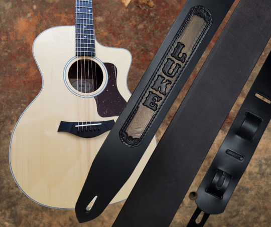 Acoustic Guitars and Great Songs and Lyrics have been staple for years in Country music!  "This 2" or 2 1/2" wide Guitar Strap is a nod to that classic influence. The main Body of the strap is approx. 1/8" thick Black Leather Strap with a CUSTOMIZABLE LEATHER NAME PATCH. The classic adjustment style goes from approx. 42" to 56" at it's longest . Made just outside Nashville in our Smyrna, TN. shop. It will need a bit of time to "break in" but will get a great patina over time.   