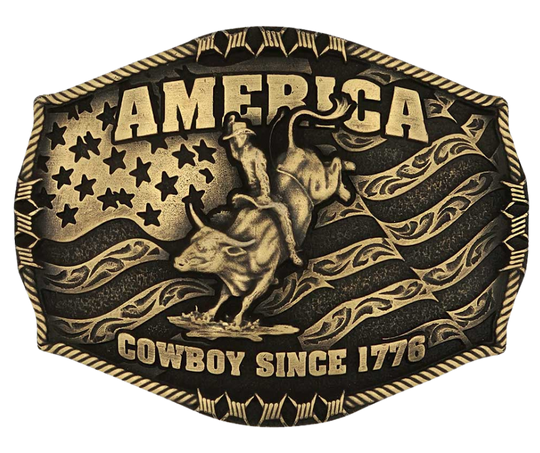 Stand for liberty and Western heritage for all with the Cowboy Since 1776 Attitude Buckle. The waving American flag provides the backdrop for the design. The word "America" sits above the bull rider figure. The words "Cowboy Since 1776" is beneath the bull rider figure. A roped border with barbed wire design creates the edge of the buckle, giving the piece a rustic look. Fits 1.5 inch belts. Find it online or at our shop just outside Nashville in Smyrna, TN.&nbsp;