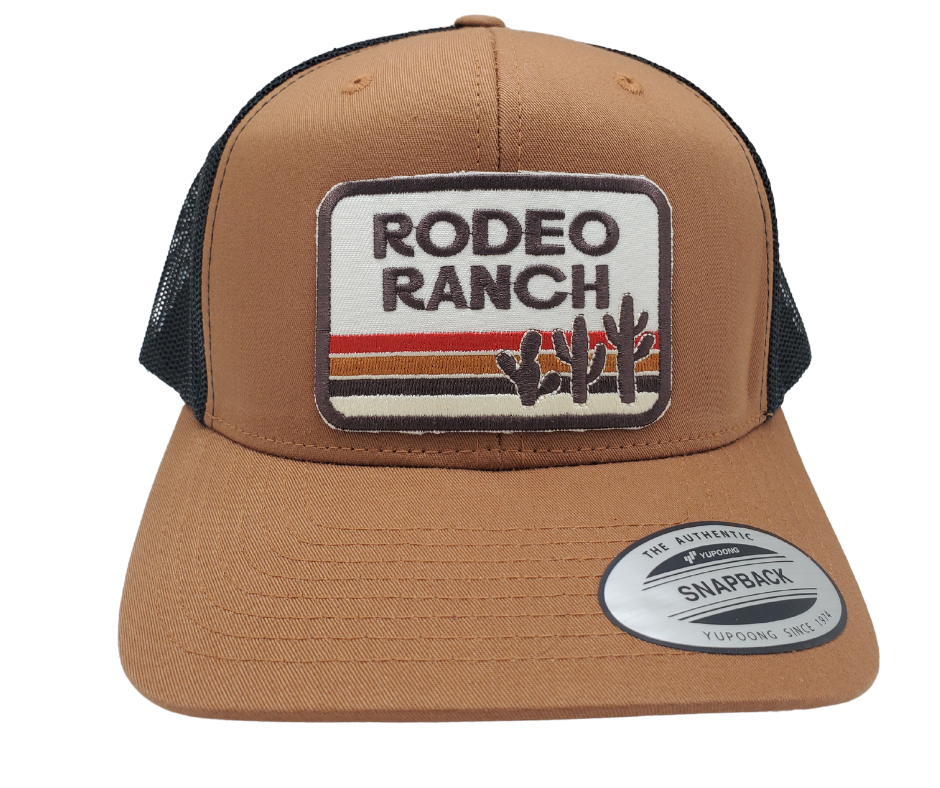 Get ready for your night out with our Rodeo Ranch Retro Cactus Cap! This trendy Embroidered Trucker Cap boasts a bold sandy color, hot desert vibes, and an iconic cactus design. Featuring a cool black mesh back, a stylish tan front, and a convenient snapped adjustable strap. Grab yours today at our shop in Smyrna, TN, right outside Nashville