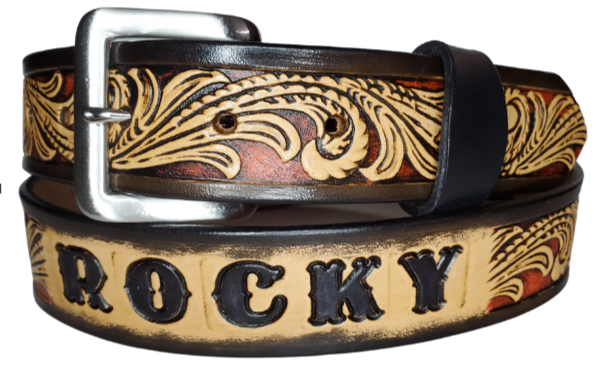 This DELUXE Rustler Name Leather Belt features a classic western Scroll pattern embossed on a 9-10 oz. vegetable-tanned cowhide. You may customize the buckle with the added snaps. It is named Deluxe because of the additional color added to the background of the pattern. This product is crafted with care in our Smyrna, TN shop, just outside Nashville, TN.