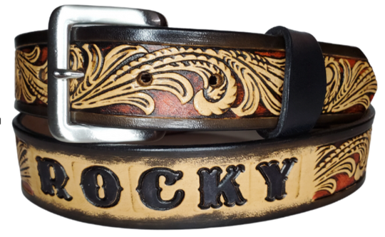 This DELUXE Rustler Name Leather Belt features a classic western Scroll pattern embossed on a 9-10 oz. vegetable-tanned cowhide. You may customize the buckle with the added snaps. It is named Deluxe because of the additional color added to the background of the pattern. This product is crafted with care in our Smyrna, TN shop, just outside Nashville, TN.