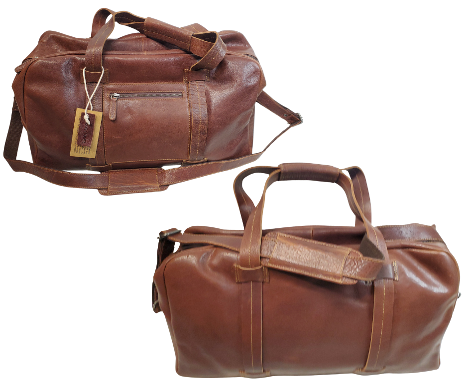 The Traveler Leather Duffel bag is available at our Smyrna, TN shop not far from Nashville. It has a single zip pocket on the side approx. 6.5 x 6.5”. Detachable leather shoulder strap is reinforced with cotton webbing, 2 leather strap handles, one on each side with reinforcement stitching and handle snaps. Spacious inside compartment with a two-way zipper. Inside pockets on each side one zips and the other is open. Lined with sturdy fabric. Bottom of bag has five rounded feet 