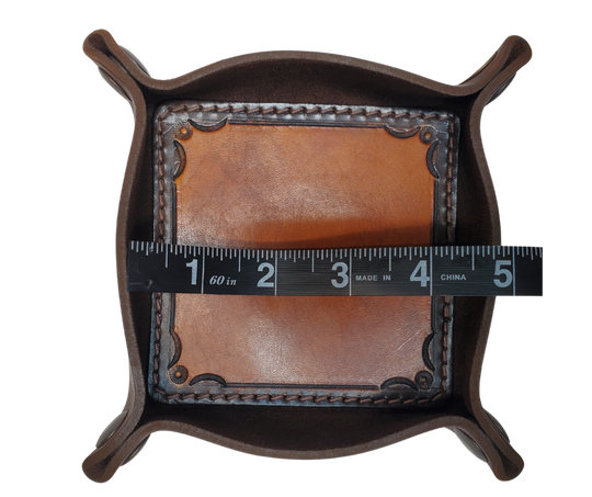 The Franklin is a stylish handmade real leather "catchall" valet tray is made from 2 layers of cowhide leather. It's a little different than our other trays because of the Hand Stamped and stained inside layer. Outer layer is a Bison brown color with the inside layer being stitched in. The corners are held together with heavy line 24 Antique Brass colored snaps, for laying flat for travel, a place for placing keys, wallet, coins.  Made in our shop just outside Nashville in Smyrna, TN.