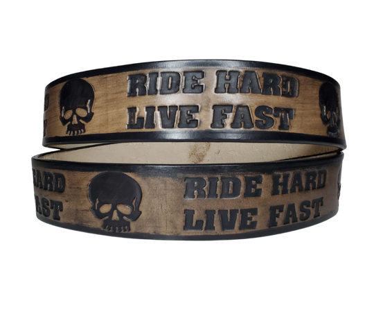 "The Daytona" is a handmade real leather belt made from a single strip of cowhide shoulder leather that is 8-10 oz. or approx. 1/8" thick. It has hand burnished (smoothed) edges and features the mantra "RIDE HARD LIVE FAST" and an HD Skull pattern down the center. This belt is completely HAND dyed with a multi step finishing technic. The antique nickel plated solid brass buckle is snapped in place with heavy snaps.  This belt is made just outside Nashville in Smyrna, TN.