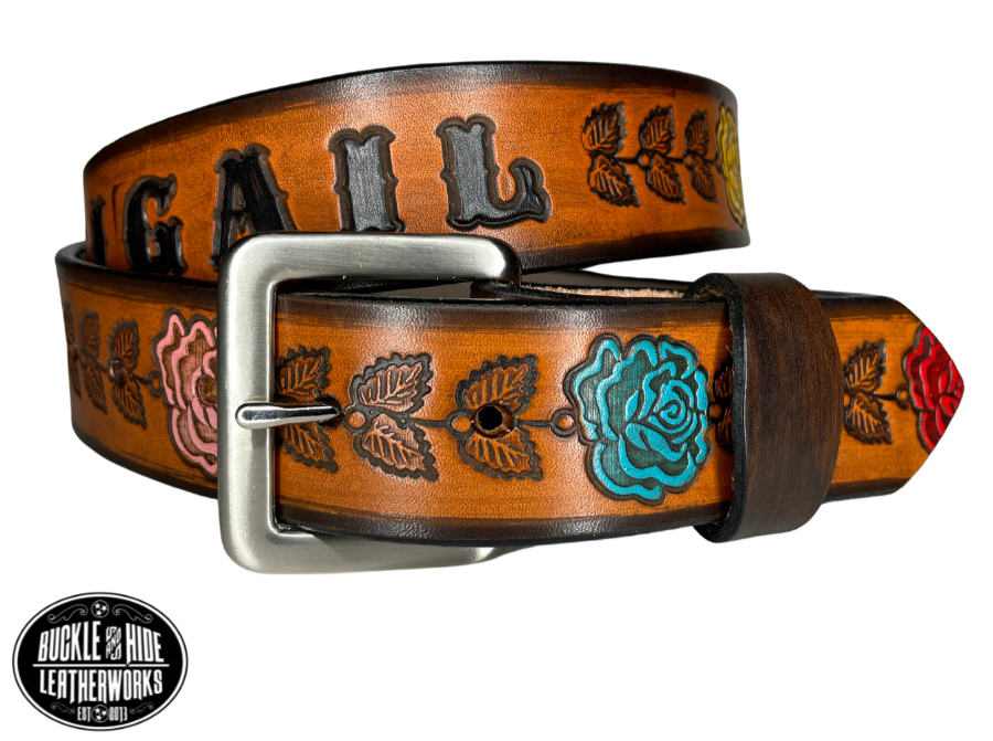 "The Heirloom Rose" is a handmade real leather belt made from a single strip of cowhide shoulder leather that is 8-10 oz. or approx. 1/8" thick. It has hand burnished (smoothed) edges and summer flowers embossed on the surface and with most HAND PAINTED in Pink, White, Yellow, Red and Turquoise. The antique nickel plated solid brass buckle is snapped in place with heavy snaps.  This belt is made just outside Nashville in Smyrna, TN.