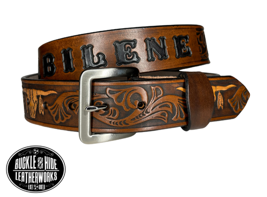 "The Longhorn"is a handmade real leather belt made from a single strip of cowhide shoulder leather that is 8-9 oz. or approx. 1/8" thick. It has smoothed edges and the Western / Longhorn scroll pattern is embossed on the surface. The antique nickel plated solid brass buckle is snapped in place.  This belt is made just outside Nashville in Smyrna, TN. 