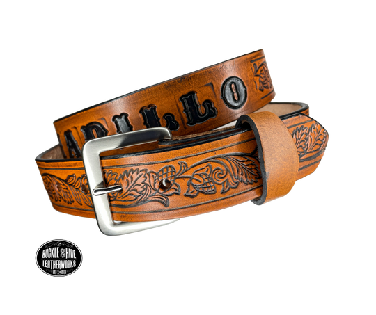 This solid strip of Veg Tan cowhide, is hand stained in 3 brown options, with smooth, finished edges. Embossed with Western Vine down length of belt, or have name added to scene up to 8 letters. Belt thickness is approx. 1/8", and 1 1/2" wide. Sizes available are 34" to 44" from buckle end to hole most worn. Attached with 2 snaps is a Brushed Nickel plated solid brass buckle. 