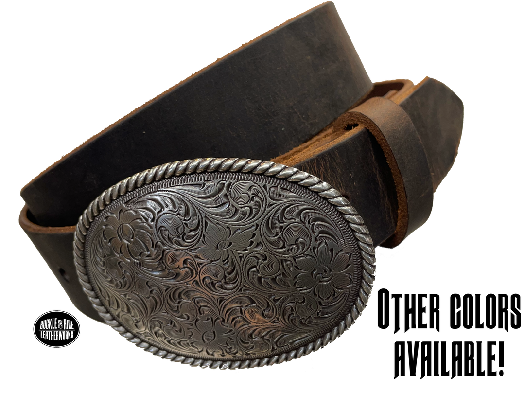 This oval shaped buckle has a rope design around the border. It is chrome colored with scroll design etched appearance on surface.  Measures 2 3/4" tall by 3 3/4" wide and fits belts up to 1 1/2" wide. Buckle is made in Taiwan. Belt is a solid strip of leather and made in our shop in Smyrna, TN, just outside Nashville. It is 1 1/2" wide and available in sizes 34"-44" and colors distressed brown, black, and dark brown. ﻿It is available for purchase in our retail shop and online store. Main photo.