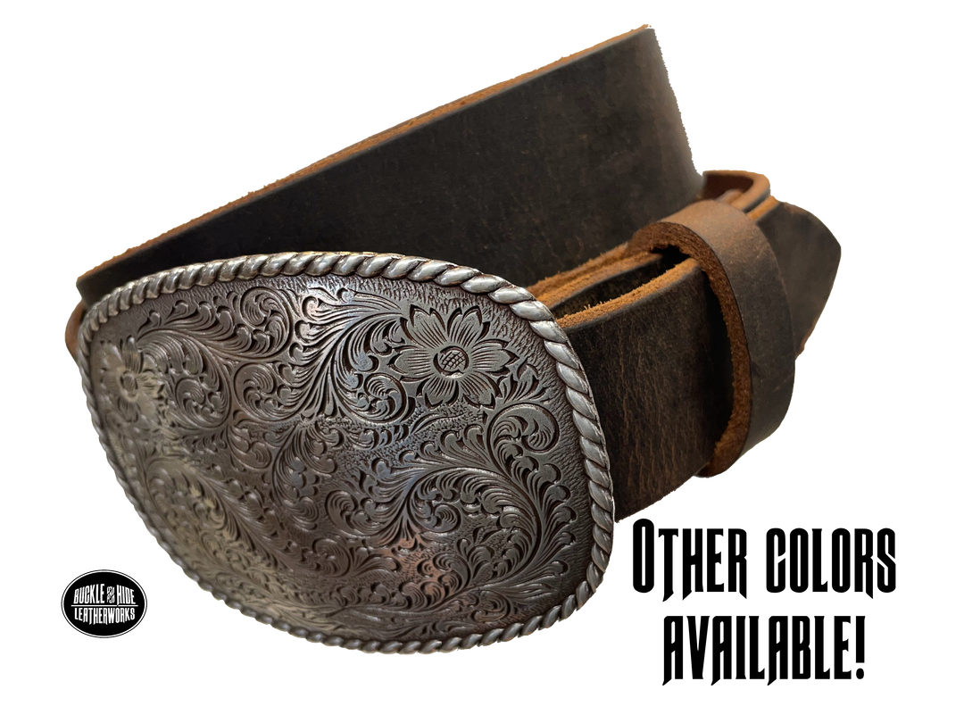 This rectangular shaped buckle has rounded edges with rope design around the border. It is chrome colored with scroll design etched appearance on surface.  Measures 2 3/4" tall by 3 3/4" wide and fits belts up to 1 1/2" wide. Buckle is made in Taiwan. Belt is a single strip of leather that is 1 1/2" wide and available in sizes 34" to 44". Colors are distressed brown, black, and dark brown. Available online and in our shop in Smyrna, TN, just outside Nashville.