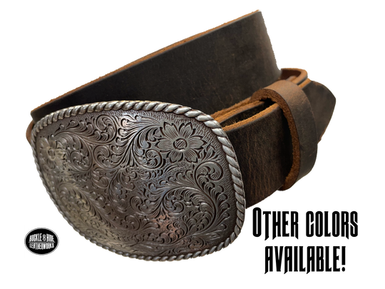 This rectangular shaped buckle by Nocona has rounded edges with rope design around the border. It is chrome colored with scroll design etched appearance on surface.  Measures 2 3/4" tall by 3 3/4" wide and fits belts up to 1 1/2" wide. Buckle is made in Taiwan. Belt is a single strip of leather that is 1 1/2" wide and available in sizes 34" to 44". Colors are distressed brown, black, and dark brown. Available online and in our shop in Smyrna, TN, just outside Nashville.