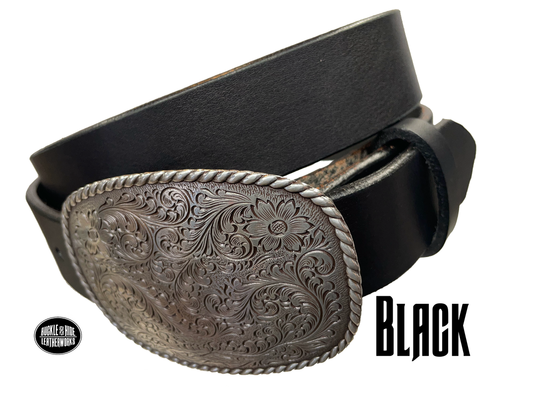 This rectangular shaped buckle has rounded edges with rope design around the border. It is chrome colored with scroll design etched appearance on surface.  Measures 2 3/4" tall by 3 3/4" wide and fits belts up to 1 1/2" wide. Buckle is made in Taiwan. Belt is a single strip of leather that is 1 1/2" wide and available in sizes 34" to 44". Colors are distressed brown, black, and dark brown. Black pictured. Available online and in our retail shop in Smyrna, TN, just outside Nashville.