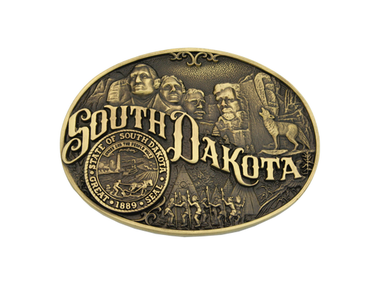 Small, oval cast brass Attitude belt buckle with polished wire trim. Large lettering spelling out South Dakota stretches boldly across, surrounded by a set of antiqued figures in celebration of South Dakota heritage including Mount Rushmore, Native American dancers and the state seal. Buckles are acid washed to add the dark antiqued patina and hand buffed to bring out the highlights and details.  Standard 1.5" belt swivel. Available online and in our shop in Smyrna, TN, just outside of Nashville.