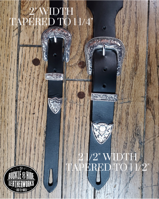 You don't get more classic Western than a handcrafted Glossy black leather guitar strap! Featuring a ornate scroll pattern 3 piece western buckle set in the front position of the strap. Each size of buckle set is similar but not the same, so check out pictures. It's made from 1/8" thick drum dyed cowhide leather and looks great with a vintage "Tele". The main strap is made from a single strip of leather with beveled and .  Made just outside Nashville in Smyrna, TN. 