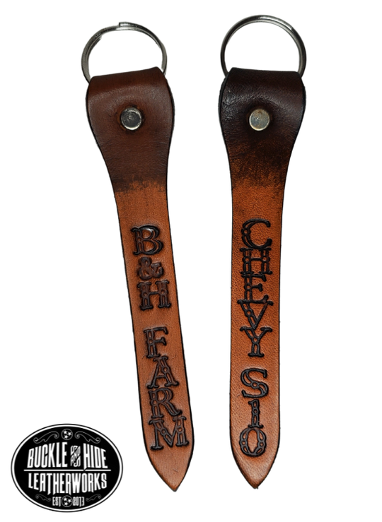 Our Leather keychain embossed similar to our popular belts.  Add your name MAXIMUM OF 8 LETTERS! Great for identifying luggage, backpacks, or you keys! Available in the below choices All colored in our popular 2 TONE BROWN, pick one or a few. Made in our Smyrna Tn. shop.